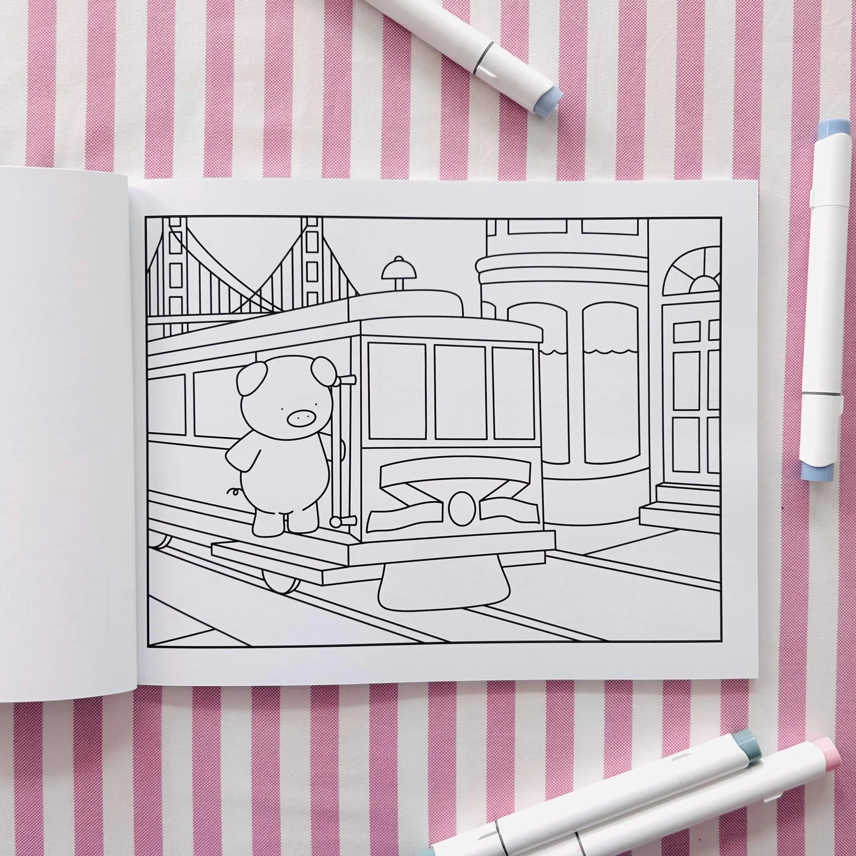Open coloring book page of a pig riding a San Fransisco trolley car.